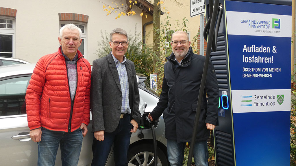 Ulrich Drolshagen und Josef Baußmann (Geschäftsführung Gemeindewerke Finnentrop GmbH) mit Bürgermeis-ter Achim Henkel an der neuen Schnellladesäule am Bahnhof